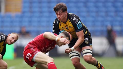 Ryan Woodman of Dragons is tackled by Gareth Davies of Scarlets