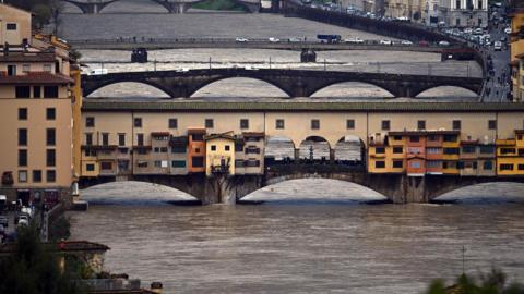 A view from above of the swollen Arno river running underneath three bridges