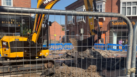 Digger fixing a hole in the road