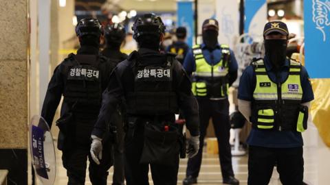 Police control access to the scene of a stabbing rampage at a department store adjacent to Seohyeon Station in Seongnam