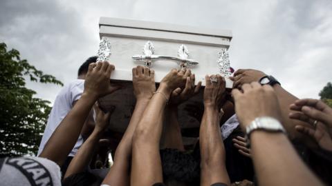 Relatives of Kian Delos Santos carry his coffin at a cemetery in Manila, 26 August