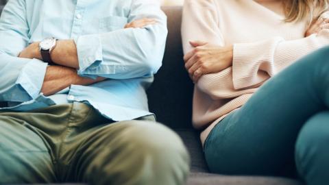 A couple looking stressed out on a couch