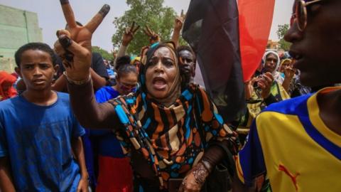 A Sudanese protesters flashes the V-sign during a mass demonstration against Sudan's ruling generals in Khartoum on June 30, 2019