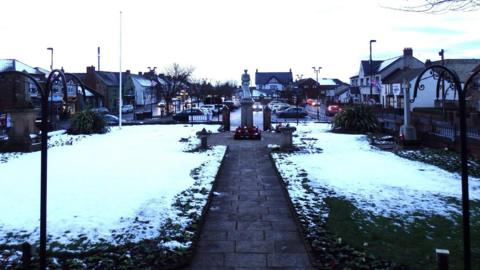The square outside of the Ferryhill Town Council building is carpeted in snow.