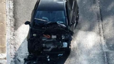 Smashed up black car