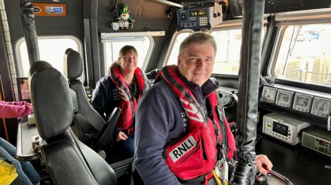Helen and Allan Thornhill wearing life jackets on board the lifeboat at RNLI Buckie in Scotland