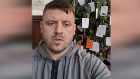 A man in a grey hoodie