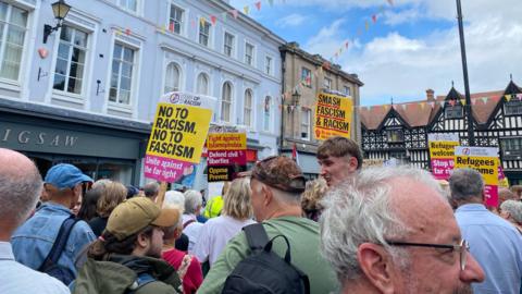 A group of people in The Square, Shrewsbury, holding anti-racism placards