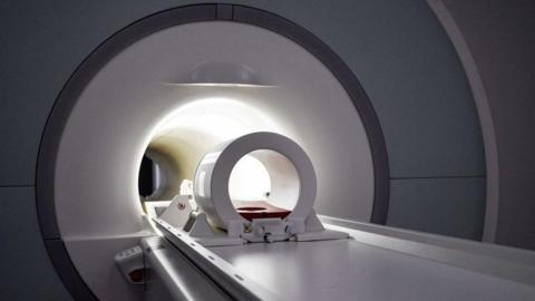 An MRI scanner, showing the stretcher and frame for holding a patients head