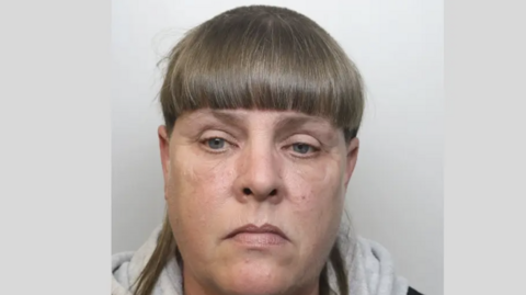 Photo of Jane Hill - she is wearing a grey hoodie top and not smiling.