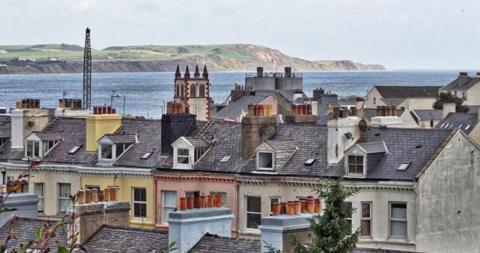 Rooftops of houses with the sea in the background