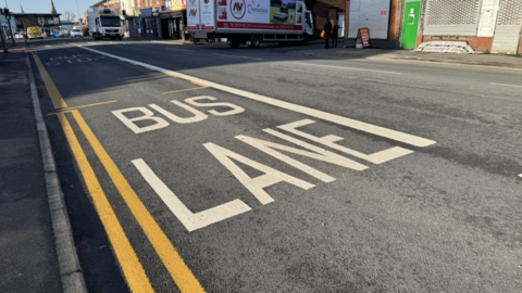 A bus lane in London Road, with a lorry in the distance.