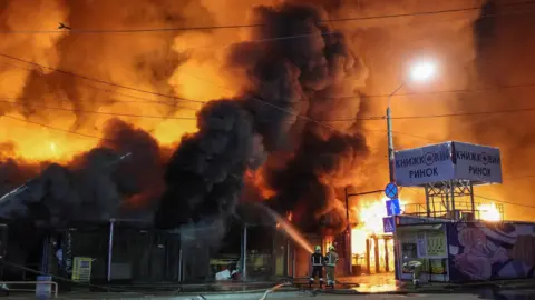 Firefighters work at a site of a book market hit by a Russian missile strike