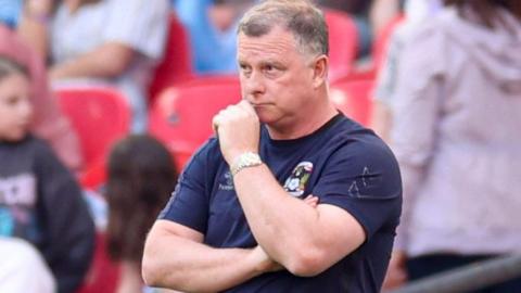 Coventry City manager Mark Robins stands on the touchline