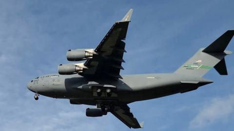  A large grey military jet aircraft against a blue sky