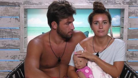 Jack Fincham and Dani Dyer holding a baby doll