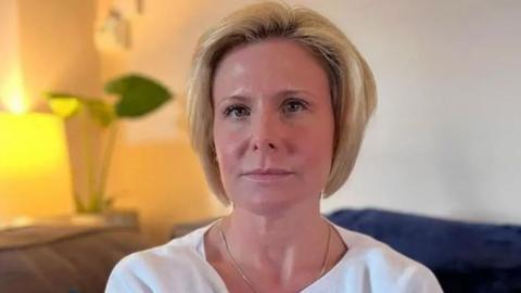 Woman with short blond hair in a white shirt