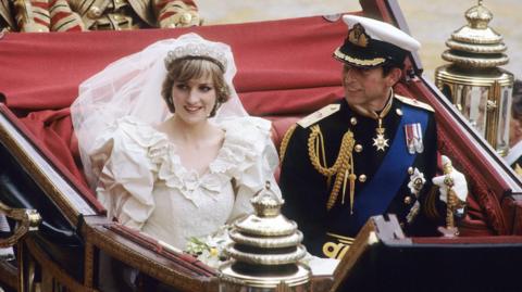 King Charles and Diana in her wedding dress on their wedding day in a chariot.