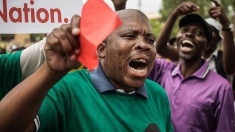 South Africans shout slogans as they take part in a protest for the resignation of South African President Jacob Zuma