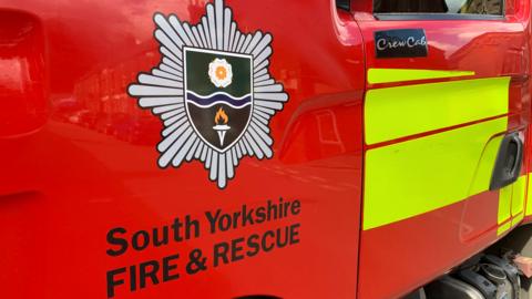 An image of the South Yorkshire Fire and Rescue Service logo on the side of a fire engine.