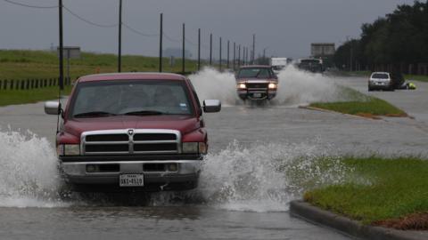 ehicles drive along a flooded road beside the Barker Reservoir after the Army Corp of Engineers started to release water into the Clodine district as Hurricane Harvey caused heavy flooding in Houston, Texas on August 29, 2017