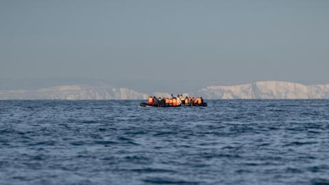 A generic shot of a small boat in the Channel with the White Cliffs of Dover in the background.