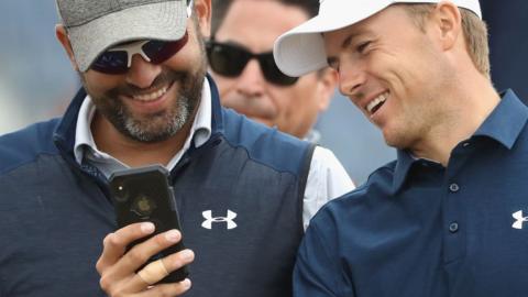 Jordan Spieth (right) and his caddie Michael Greller looking at a phone