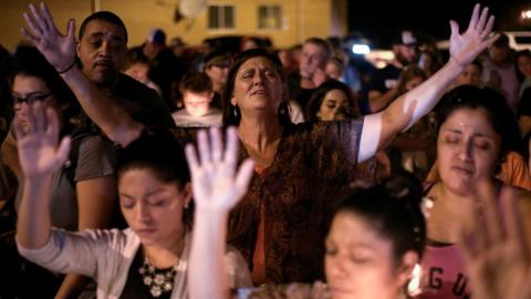 A crowd of people at a candle light vigil