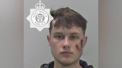 A mug shot of Oliver Barber. He has brown hair and a large facial injury to his left cheek