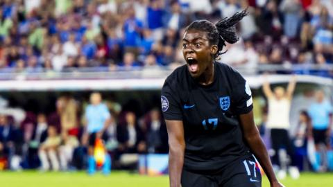 Michelle Agyemang in England kit shouting as she runs across the pitch after scoring a goal