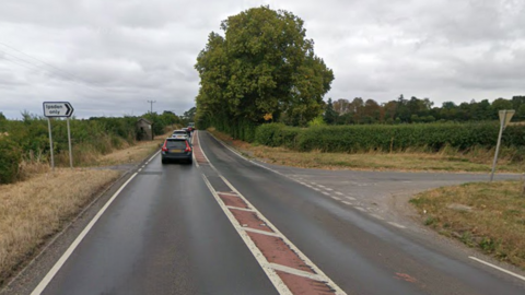 A fairly straight single carriageway has a sign pointing to a right turn, with the words "Ipsden only"