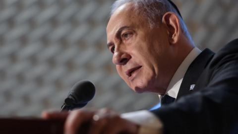 Israeli Prime Minister Benjamin Netanyahu speaking into a microphone