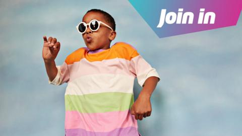 A boy is dancing wearing white sunglasses and a stripy t-shirt.