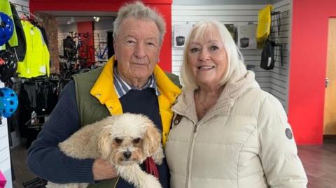 Vik and Kates groves holding their dog Daisy