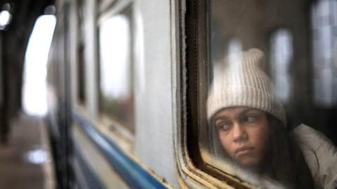 A girl fleeing the Ukraine war by train from Lviv to Poland