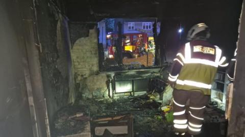 A firefighter inside the burnt property