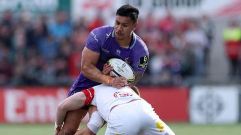 Len Ikitau is tackled around the waist by an Ulster player while holding the ball
