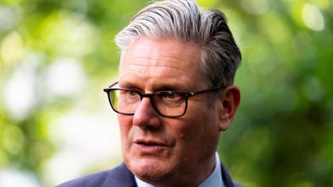 Keir Starmer looking to the side of the camera, wearing a navy suit