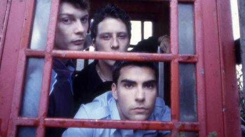 Photograph of the original Stereophonics line-up in a red phone box - Richard Jones, Stuart Cable and Kelly Jones pictured.