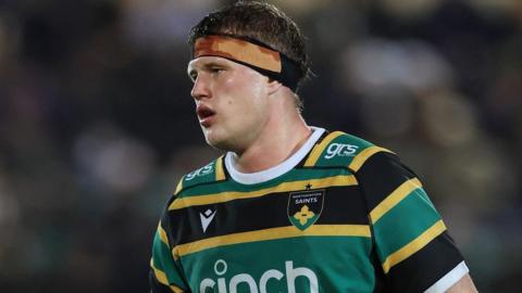 Archie Benson, wearing a headband, playing for Northampton Saints