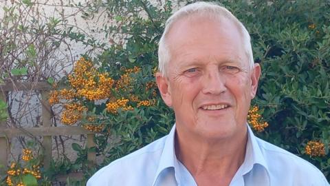 A profile shot of Martin Strong wearing a blue shirt with collar.