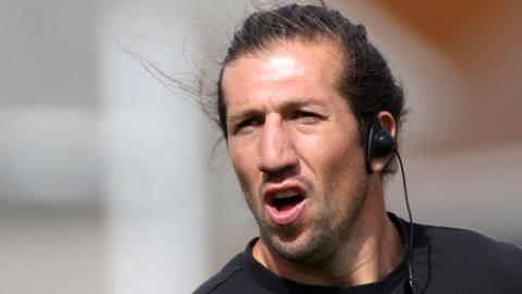 Justin Tipuric wearing an earpiece shouts from the touchline