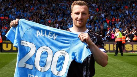 Jamie Allen holds up a special commemorative Coventry City shirt showing his surname and the number 200 underneath, marking his double century of appearances for the club.