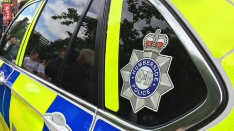 Close up of the side of a Humberside Police car with the force's badge in the back window