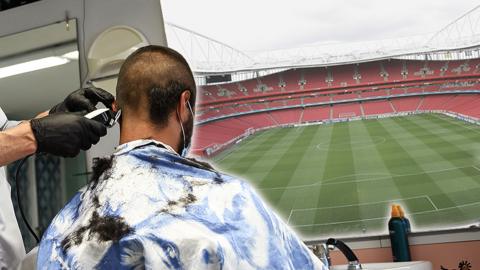 A man having a haircut while looking at a football pitch