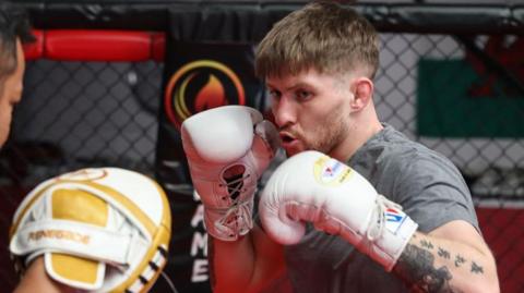 Jack Shore punches a pad in training