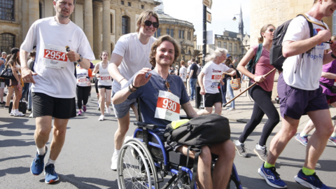 Tristan Boedts being pushed in a wheelchair by a friend in Broad Street in Oxford. 