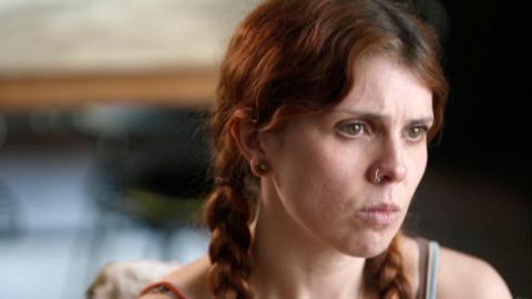 Young woman with reddish-brown hair in plaits