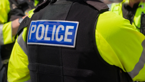The back of a police officer stood next to two others