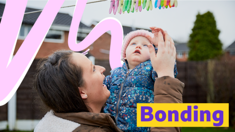 Mother and baby playing with washing line.